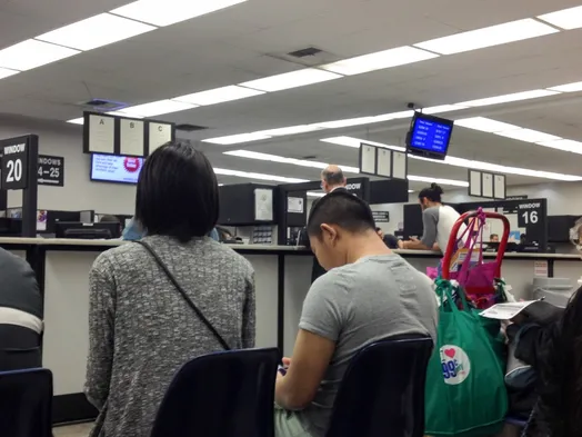 Drivers waiting at a DMV office for a license renewal written test